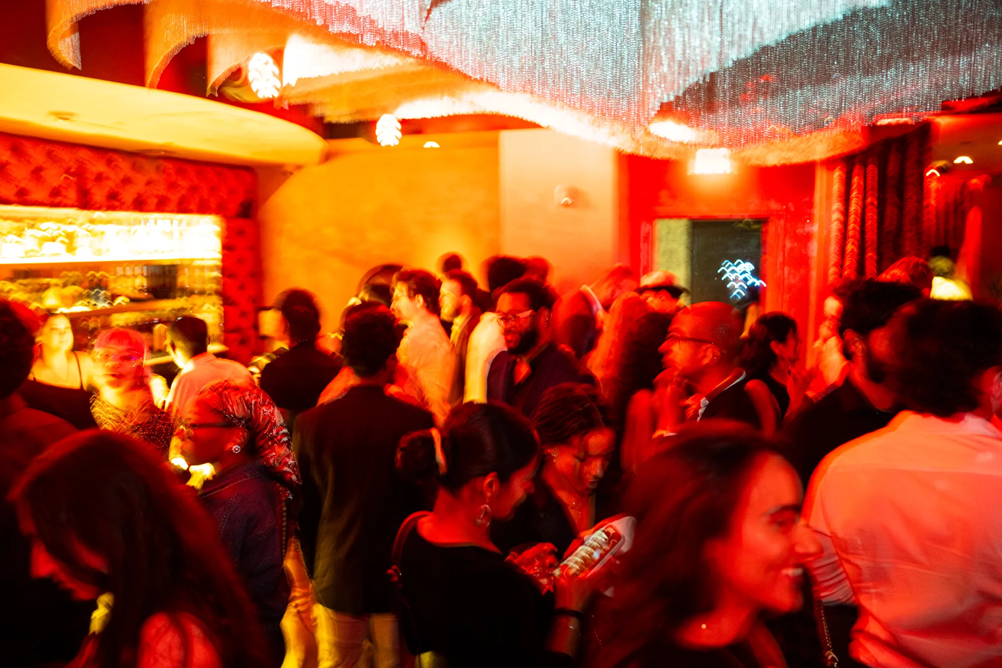 THE BACK ROOM Vol. 2 at ZUZU Detroit: a crowded room glowing red under a crystal chandelier.