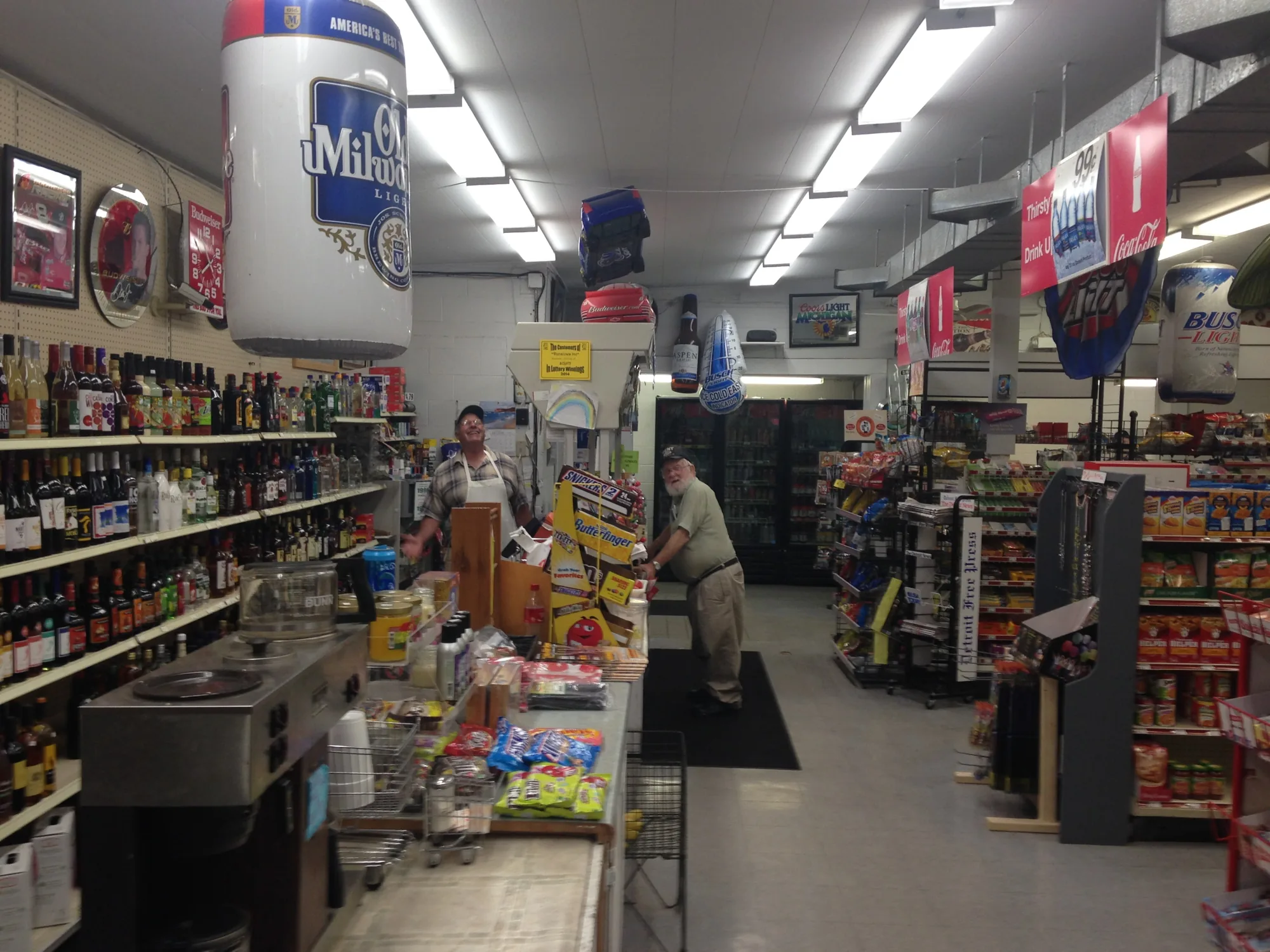 Inside Denslows Market: the register counter, liquor shelves and snack aisles.