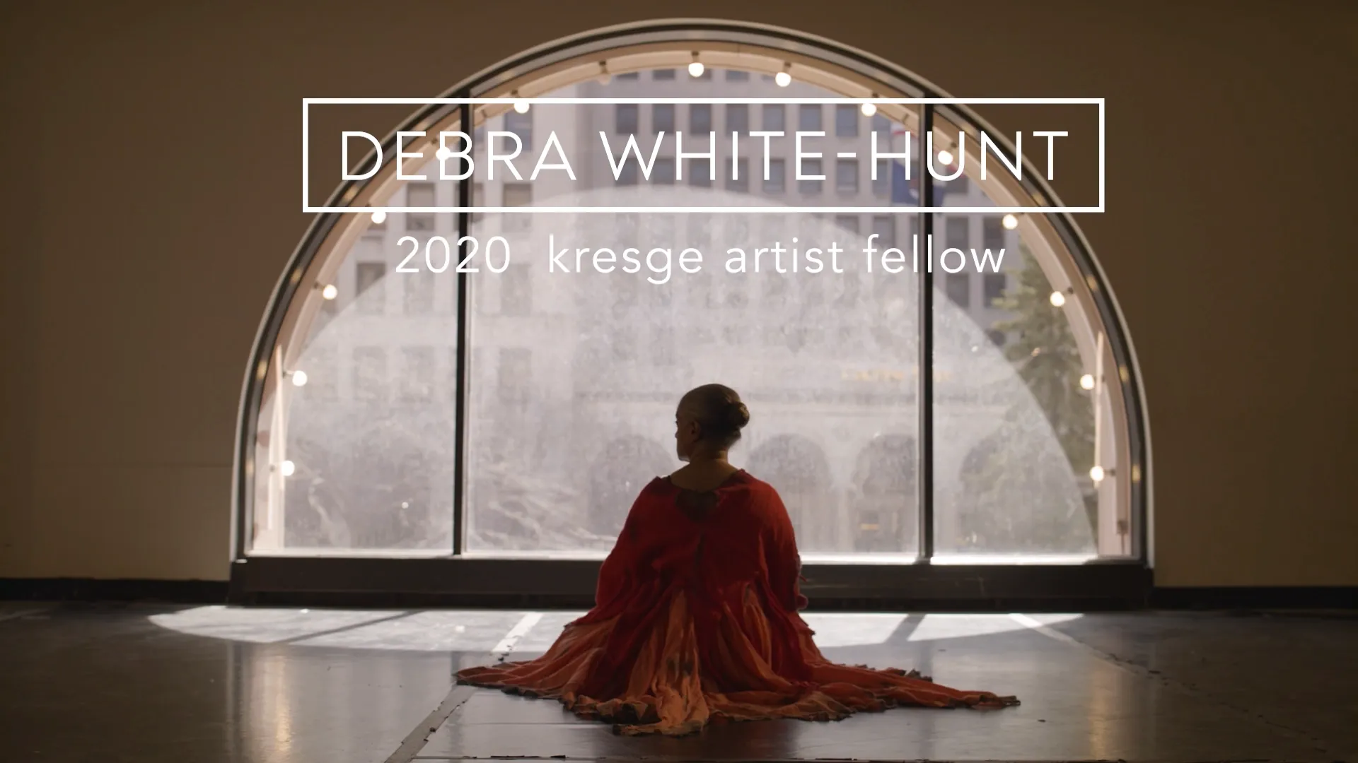 Debra White-Hunt, 2020 Kresge Artist Fellow, seated before an arched window.