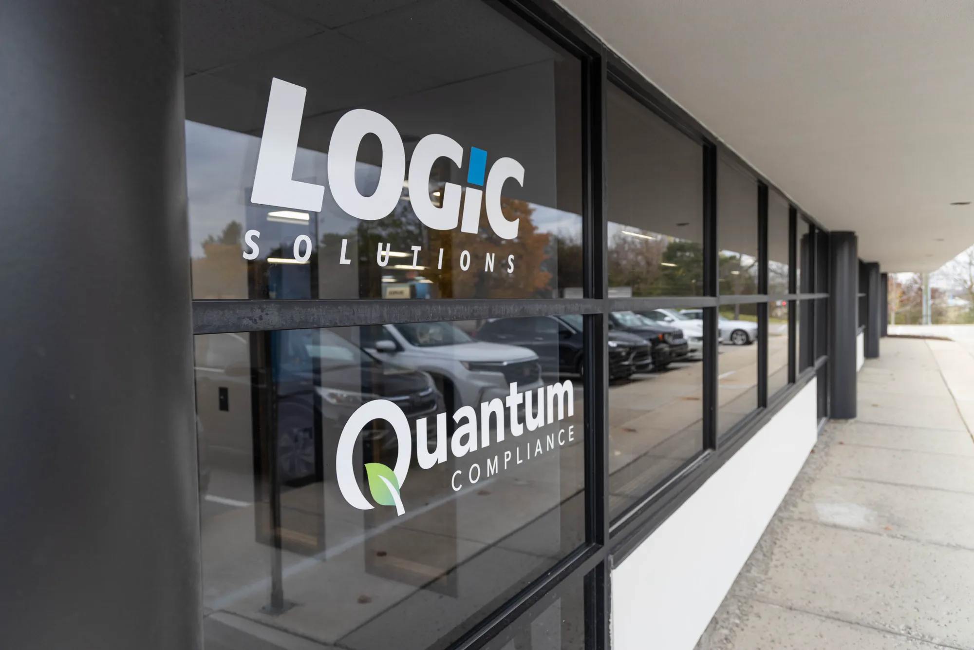 Logic Solutions and Quantum Compliance logos on the office windows